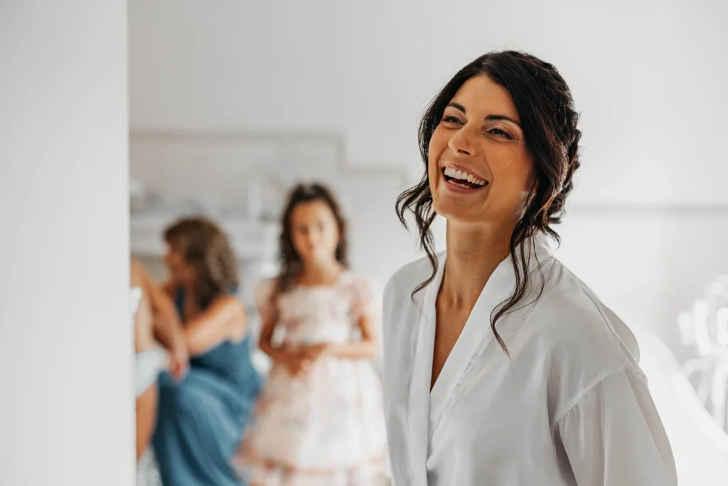 Bride laughing while getting ready with her bridesmaids