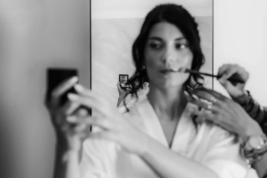Bride taking a mirror selfie during hair and makeup
