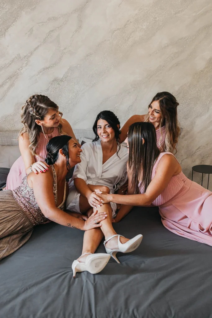 Bride and bridesmaids sharing stories while getting ready