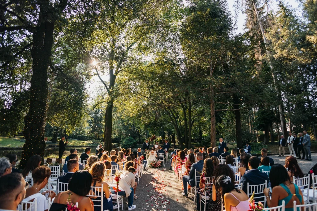 Outdoor wedding ceremony with guests seated under the trees