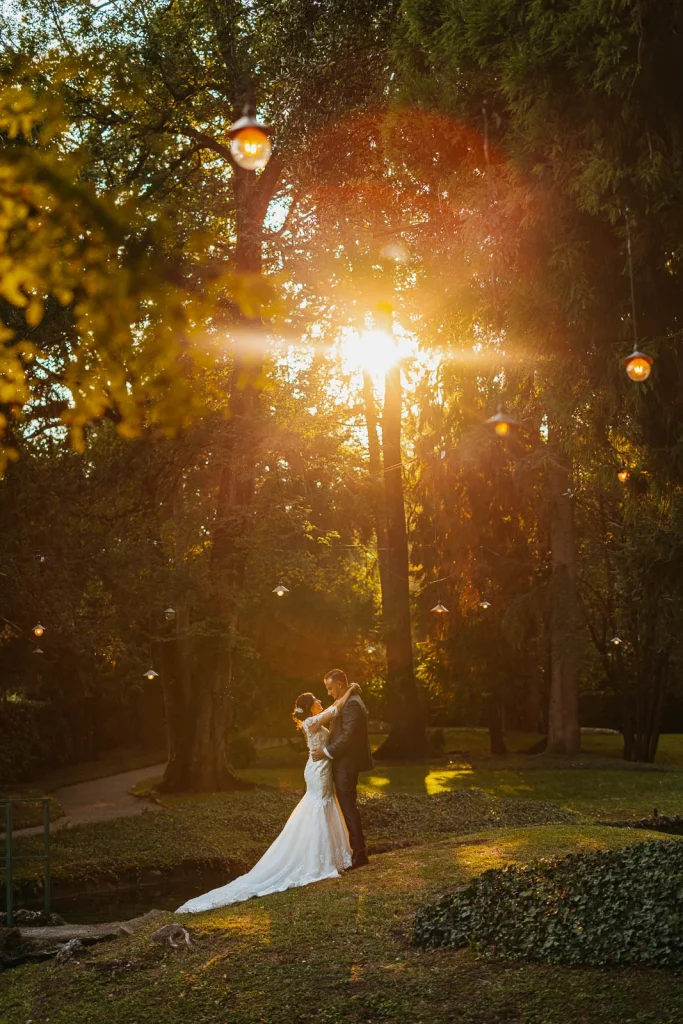 Bride and groom kissing in a sun-drenched garden