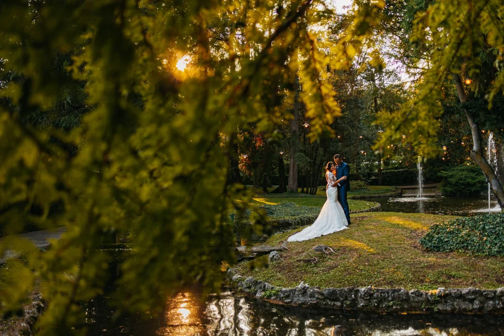 Bride and groom walking down a tree-lined path