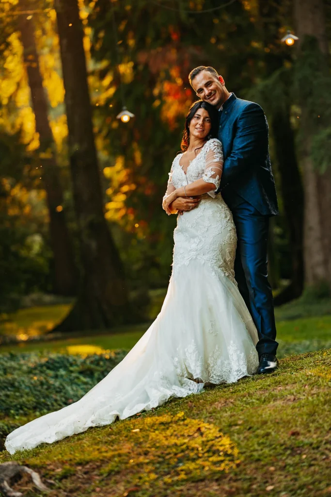 Groom lifting bride in the park at sunset