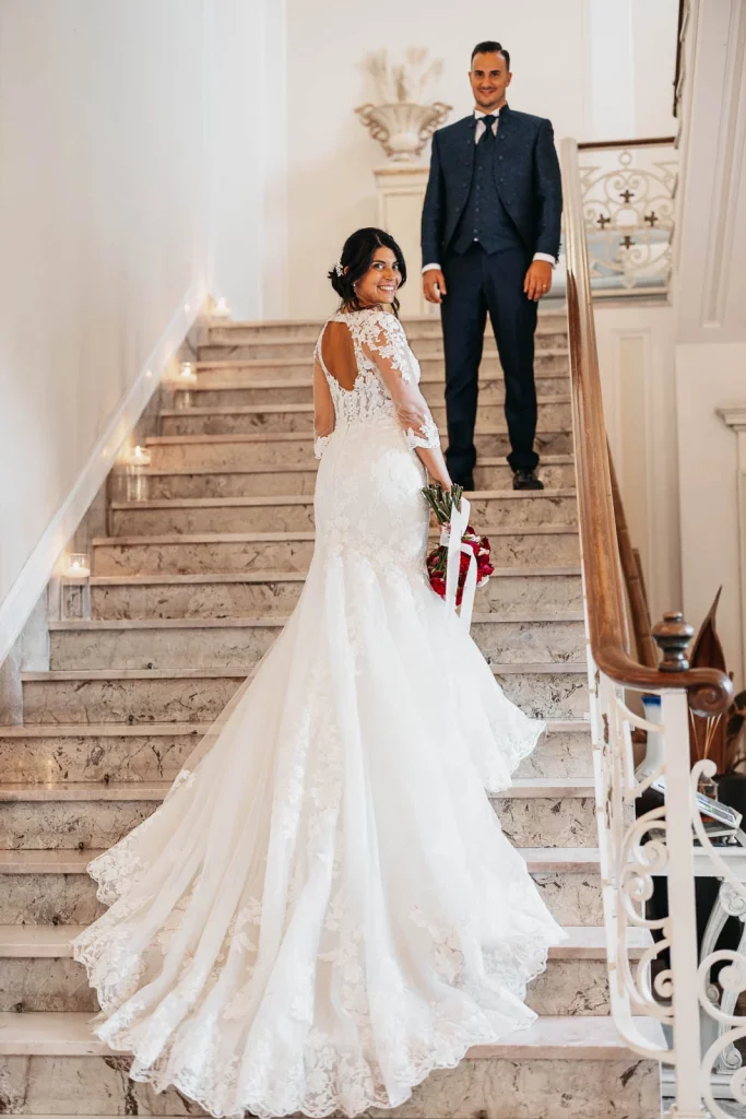Bride walking down the elegant staircase of Villa Acquaroli