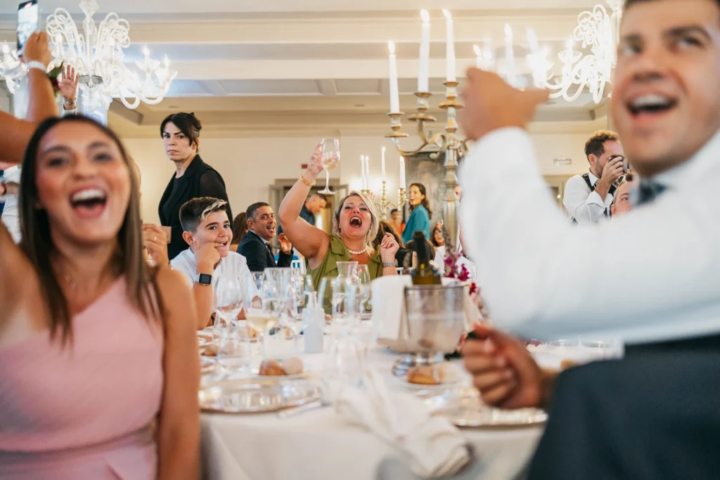 Wedding guests clapping and smiling at the reception table