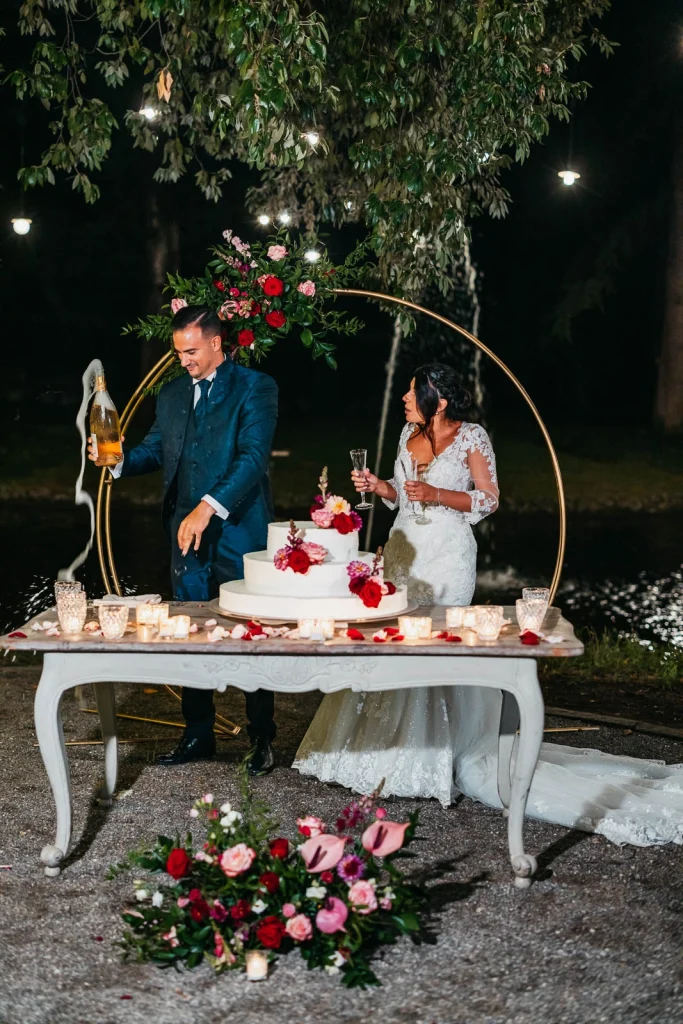 Outdoor cake table with floral decorations and fairy lights
