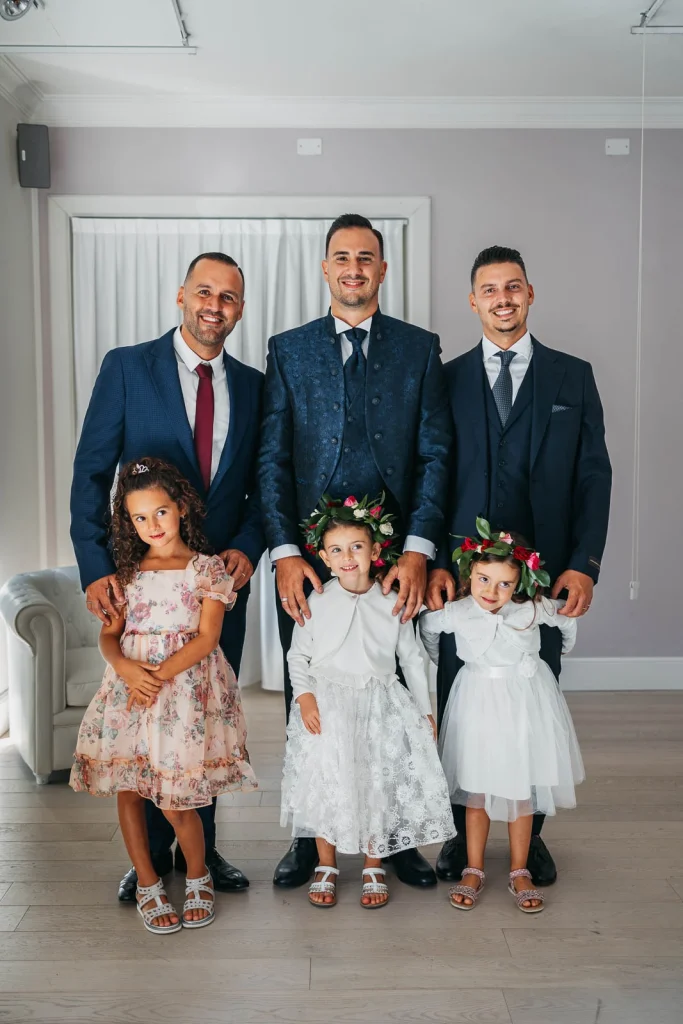 Group photo with groom, groomsmen, and flower girls