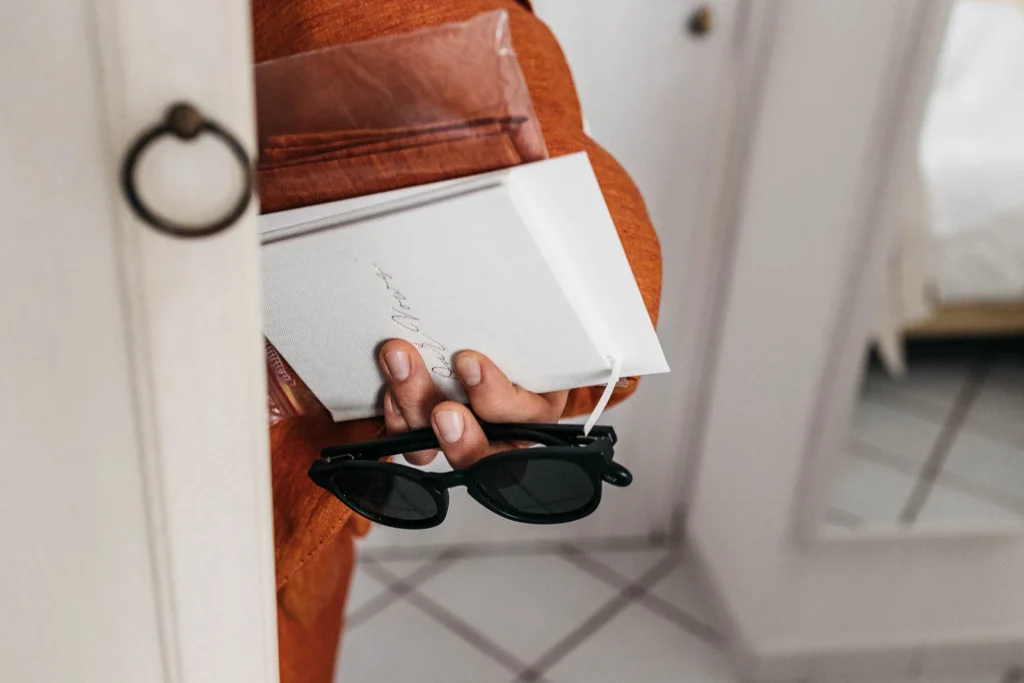 Ravello Wedding at Belmond Hotel Caruso – Amalfi Coast Destination Wedding 15 Gift box, sunglasses, and groom accessories on a bed
