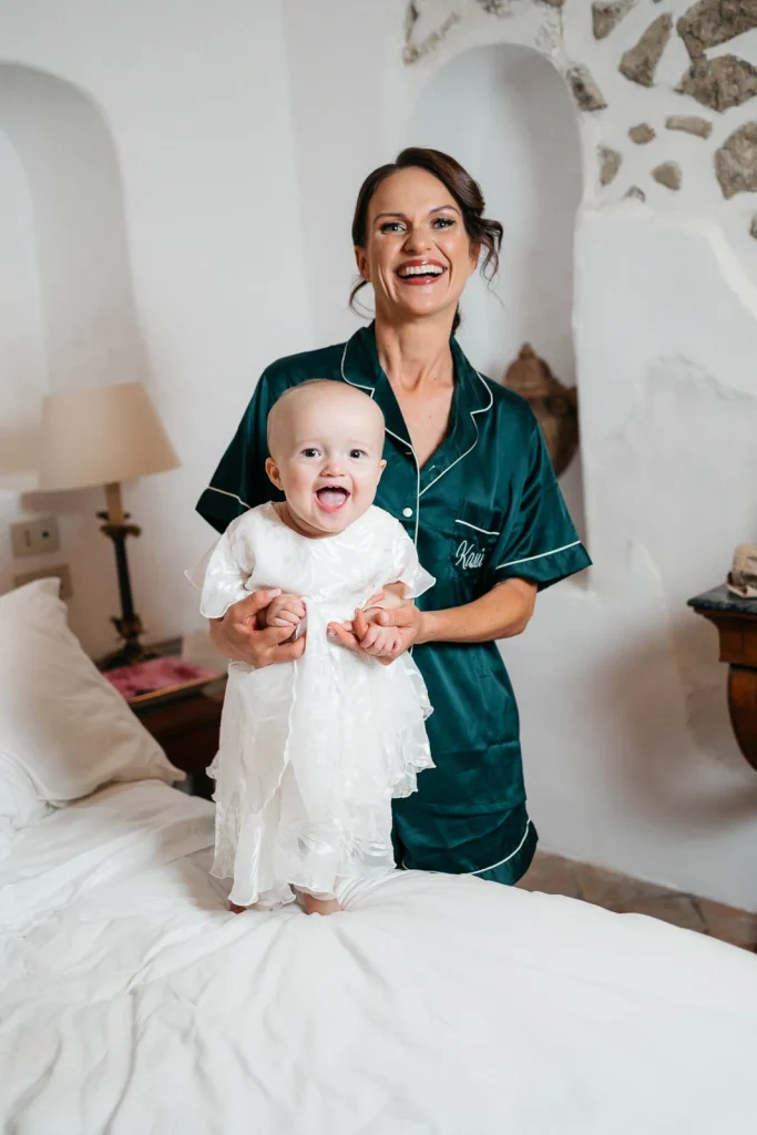 Ravello Wedding at Belmond Hotel Caruso – Amalfi Coast Destination Wedding 24 Bride holding her daughter while smiling in a white dress