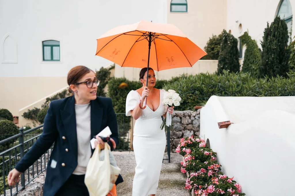 Ravello Wedding at Belmond Hotel Caruso – Amalfi Coast Destination Wedding 31 Bridesmaid walking with umbrella and paper bag in Ravello