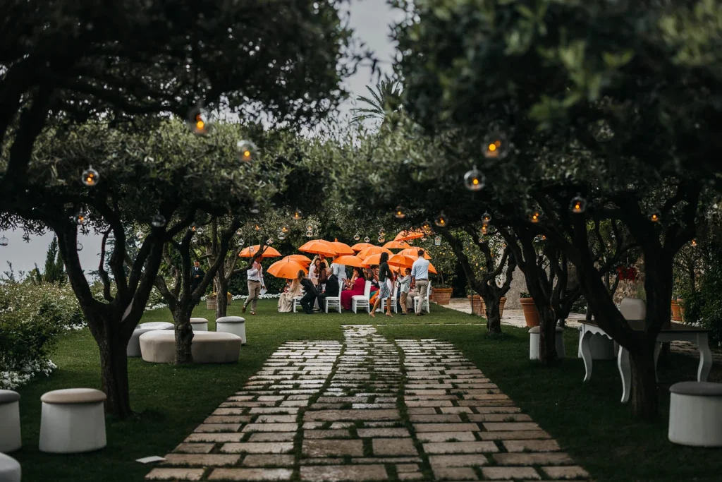 Ravello Wedding at Belmond Hotel Caruso – Amalfi Coast Destination Wedding 32 Ceremony aisle lined with orange umbrellas and lush greenery