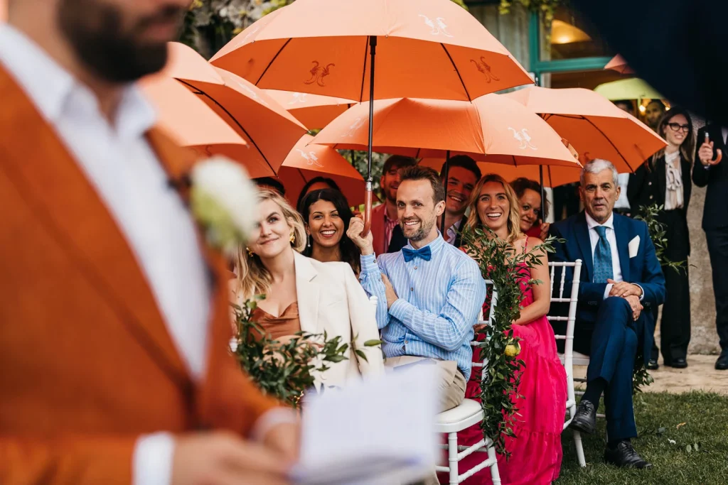 Ravello Wedding at Belmond Hotel Caruso – Amalfi Coast Destination Wedding 42 Guests smiling under umbrellas during wedding ceremony