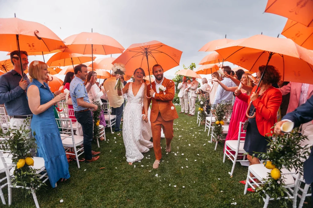 Ravello Wedding at Belmond Hotel Caruso – Amalfi Coast Destination Wedding 45 Newlyweds walking down the aisle with guests holding orange umbrellas