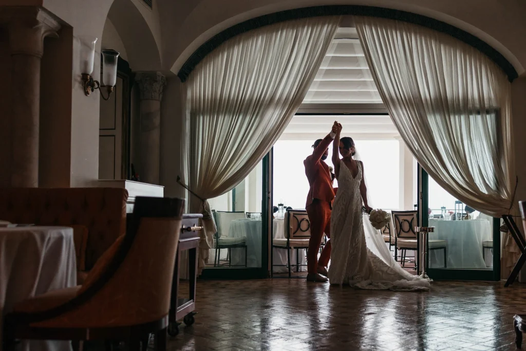 Ravello Wedding at Belmond Hotel Caruso – Amalfi Coast Destination Wedding 47 Bride and groom by the large window with drapes at the hotel