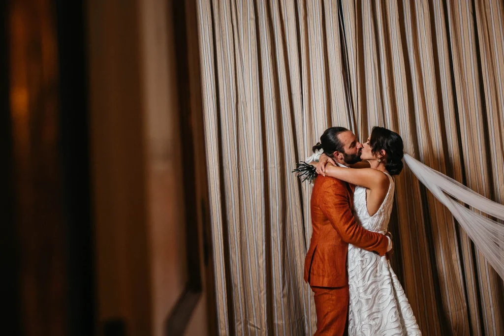 Ravello Wedding at Belmond Hotel Caruso – Amalfi Coast Destination Wedding 48 Bride and groom sharing a kiss beside velvet curtains