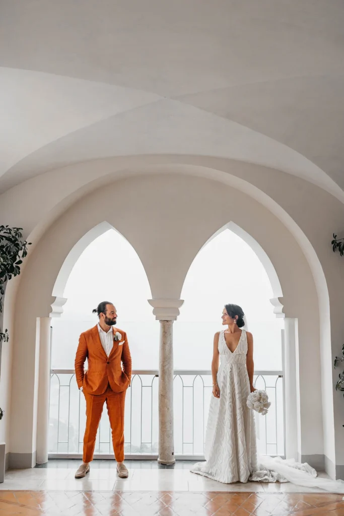 Ravello Wedding at Belmond Hotel Caruso – Amalfi Coast Destination Wedding 50 Bride and groom standing in front of arched windows with the sea view