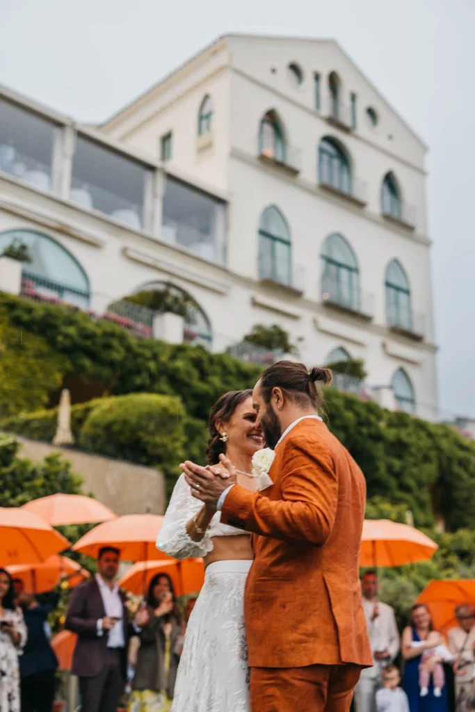 Ravello Wedding at Belmond Hotel Caruso – Amalfi Coast Destination Wedding 56 Groom kissing bride while sitting outdoors after ceremony