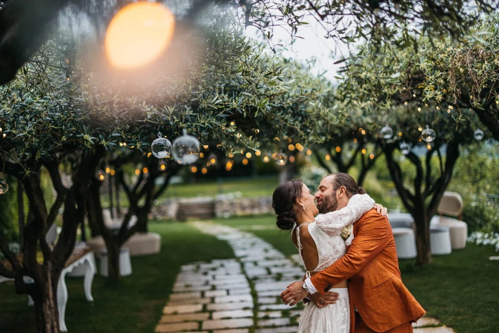 Ravello Wedding at Belmond Hotel Caruso – Amalfi Coast Destination Wedding 60 Bride and groom hugging under string lights in the garden