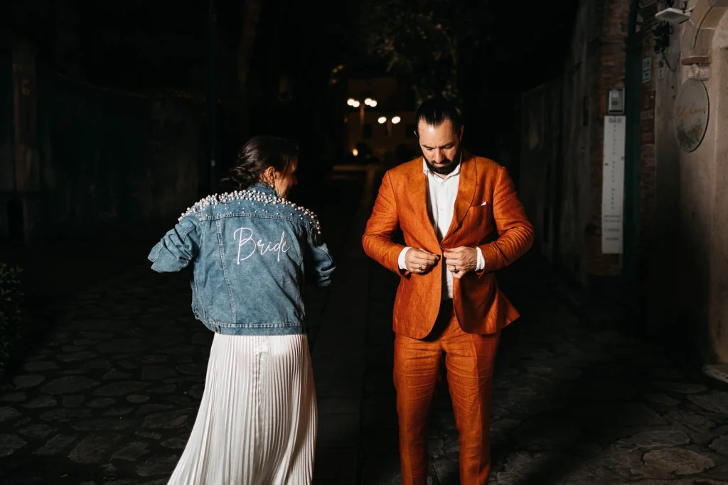 Ravello Wedding at Belmond Hotel Caruso – Amalfi Coast Destination Wedding 84 Bride wearing a denim jacket next to groom in orange suit