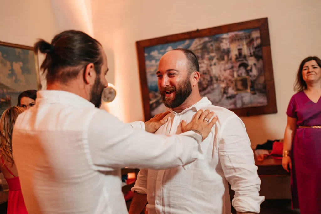 Ravello Wedding at Belmond Hotel Caruso – Amalfi Coast Destination Wedding 88 Groom laughing while hugging a guest