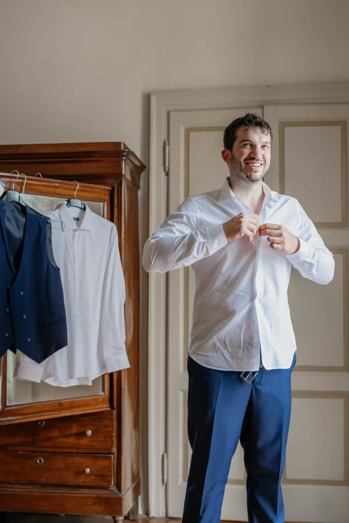 Dream Wedding at Villa Le Due Torrette in Erba: The Elegance of a Lake Como Celebration 13 Groom fixing his shirt during wedding day preparations