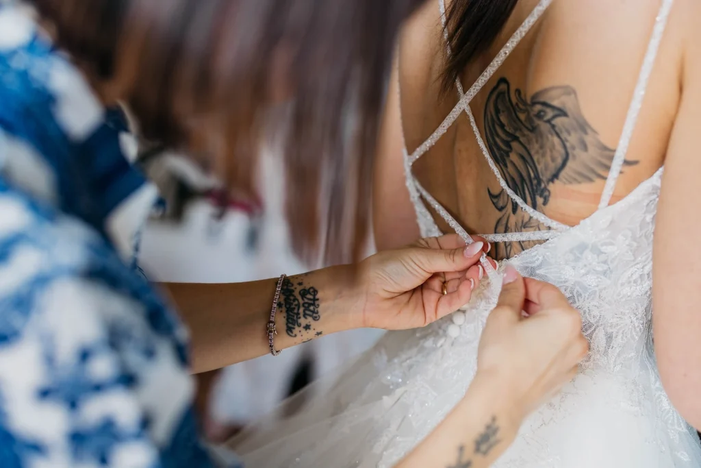Dream Wedding at Villa Le Due Torrette in Erba: The Elegance of a Lake Como Celebration 19 Close-up of bridesmaid adjusting the bride’s dress strap