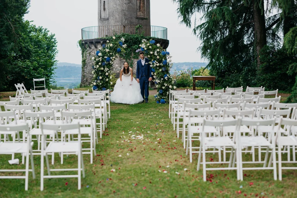 Dream Wedding at Villa Le Due Torrette in Erba: The Elegance of a Lake Como Celebration 50 Wedding ceremony chairs with scenic tower backdrop at Villa Le Due Torrette
