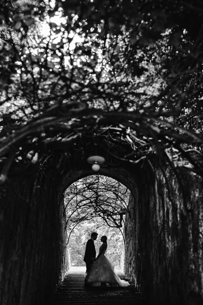 Dream Wedding at Villa Le Due Torrette in Erba: The Elegance of a Lake Como Celebration 57 Couple silhouetted under a dramatic tree tunnel at Villa Le Due Torrette