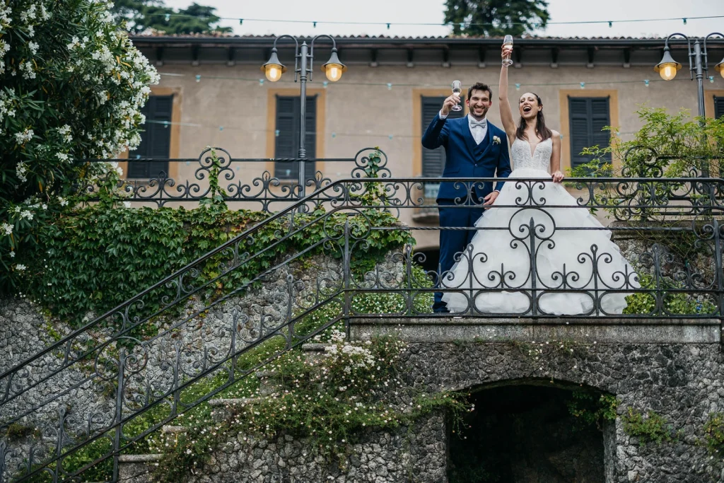 Dream Wedding at Villa Le Due Torrette in Erba: The Elegance of a Lake Como Celebration 62 Wedding couple posing on villa balcony with Lake Como view
