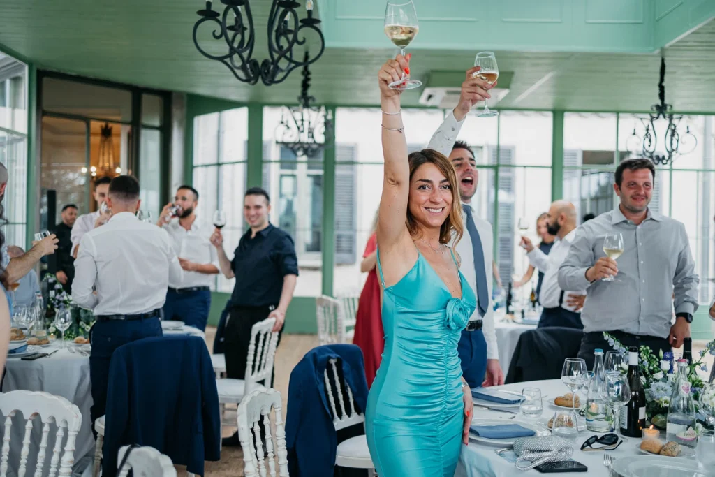 Dream Wedding at Villa Le Due Torrette in Erba: The Elegance of a Lake Como Celebration 75 Woman in blue dress raising glass at Villa Le Due Torrette wedding