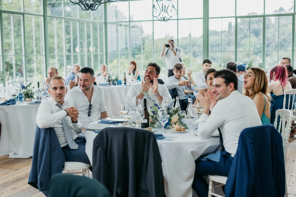 Dream Wedding at Villa Le Due Torrette in Erba: The Elegance of a Lake Como Celebration 79 Guests enjoying lunch at wedding reception with glass walls and garden view