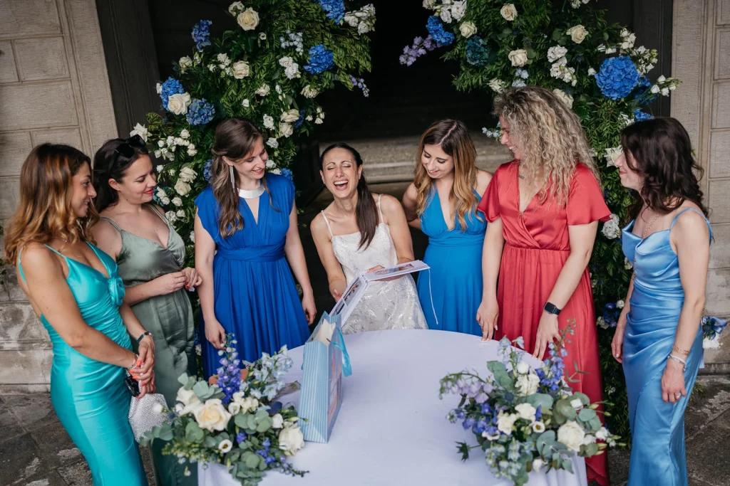 Dream Wedding at Villa Le Due Torrette in Erba: The Elegance of a Lake Como Celebration 86 Bride surrounded by bridesmaids in vibrant blue dresses at Lake Como wedding