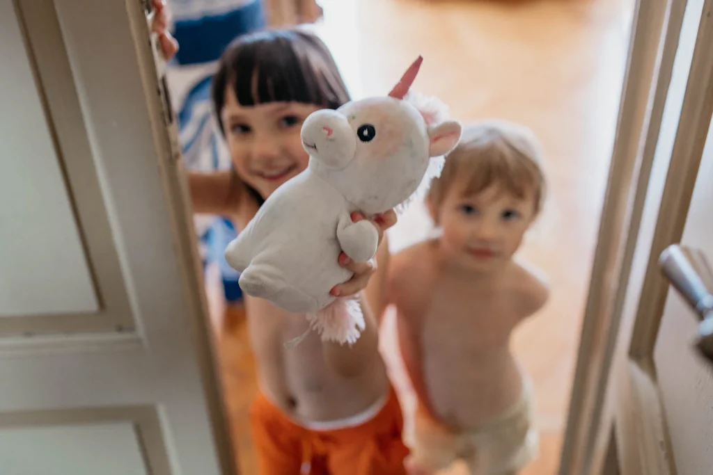 Dream Wedding at Villa Le Due Torrette in Erba: The Elegance of a Lake Como Celebration 9 Children playing with a unicorn plush toy during a family wedding at Lake Como