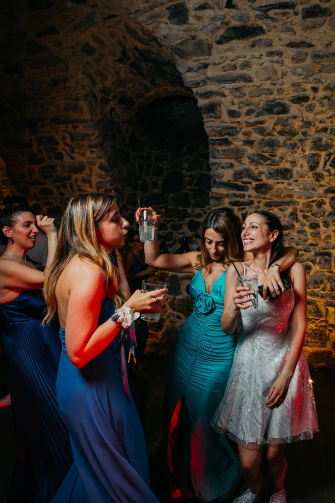 Dream Wedding at Villa Le Due Torrette in Erba: The Elegance of a Lake Como Celebration 91 Wedding guests dancing and celebrating inside rustic stone hall at Lake Como venue