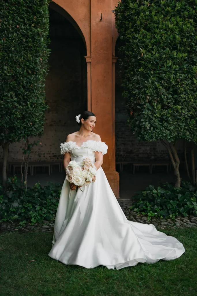 Romantic bridal portrait holding soft pastel rose bouquet in natural light
