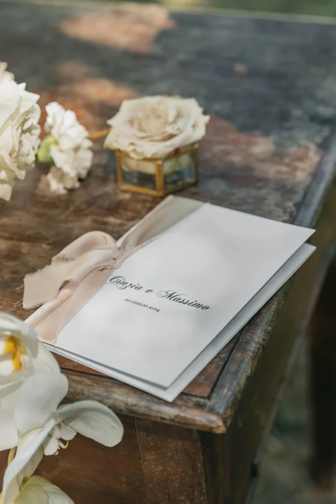 Ceremony program with dried flowers and wax seal on rustic table