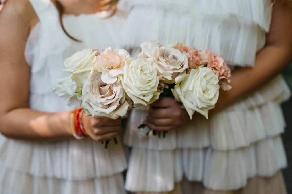 Bridesmaids holding natural, pastel-toned flower bouquets in a close-up