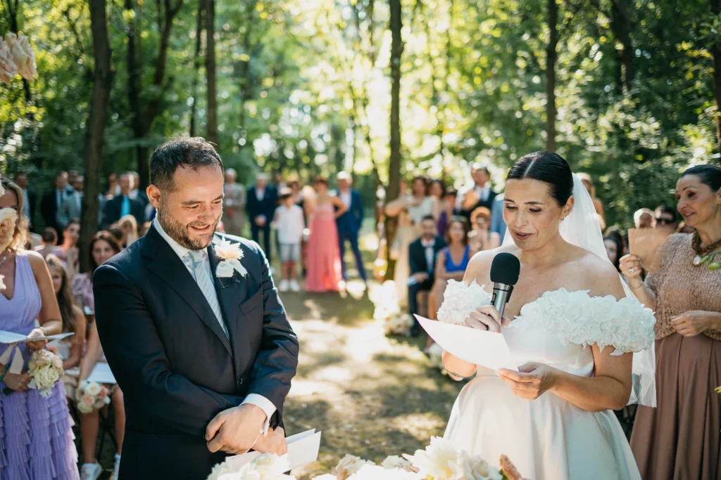 Groom and bride standing in front of guests at the start of the outdoor ceremony