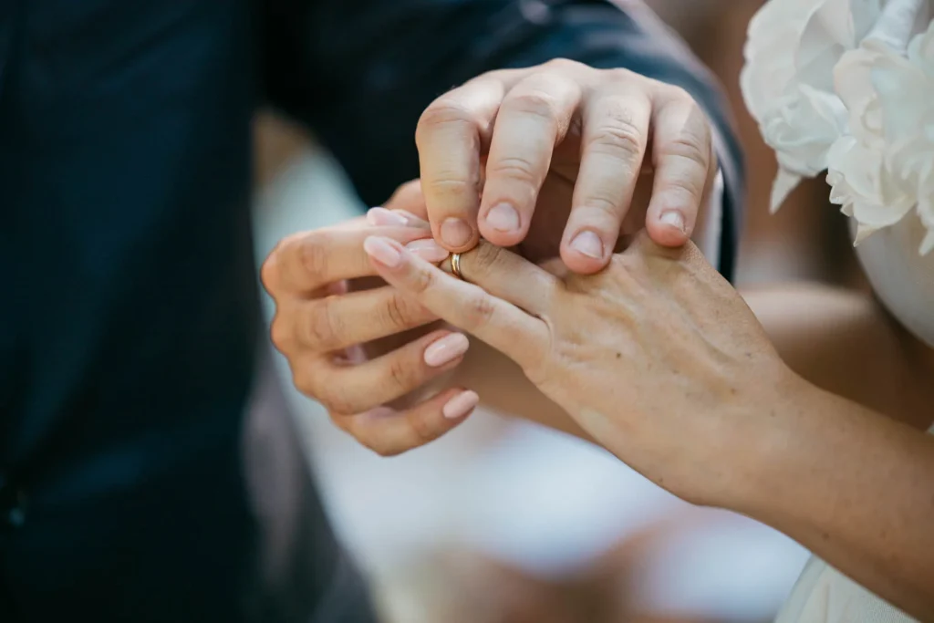 Close-up of bride and groom’s hands during the ring exchange