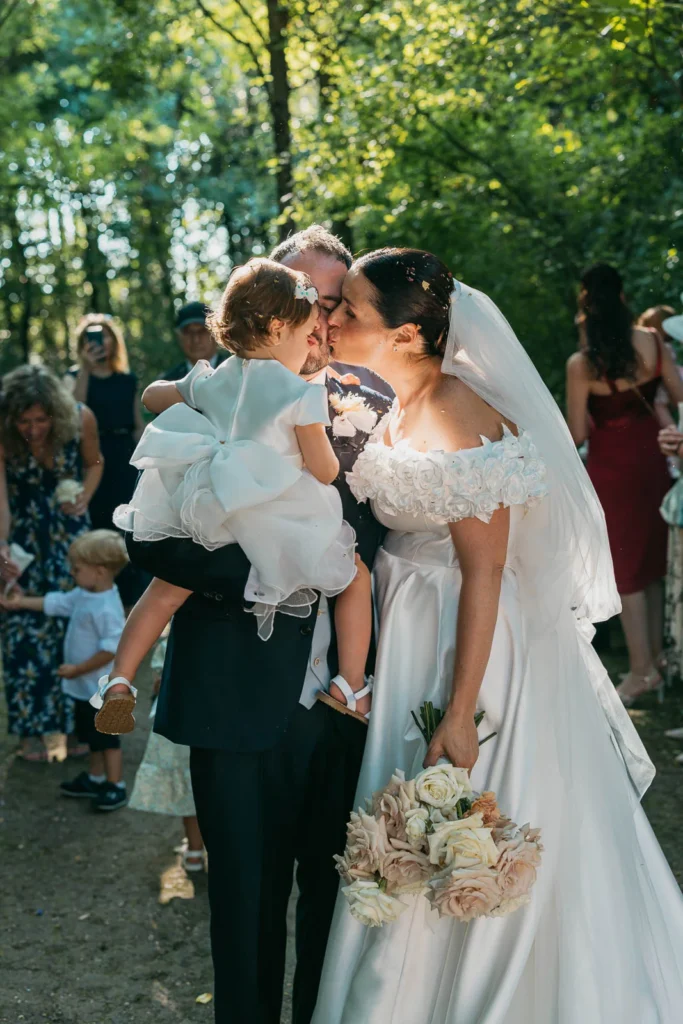 Bride holding baby while smiling during the emotional ceremony