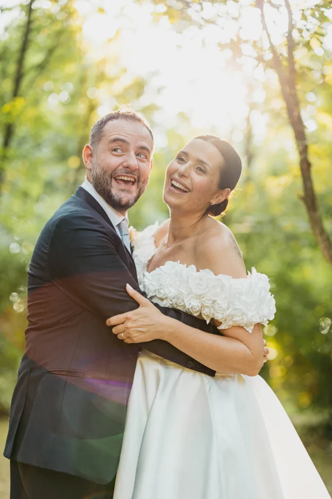Bride and groom smiling together after the ceremony surrounded by sunlight