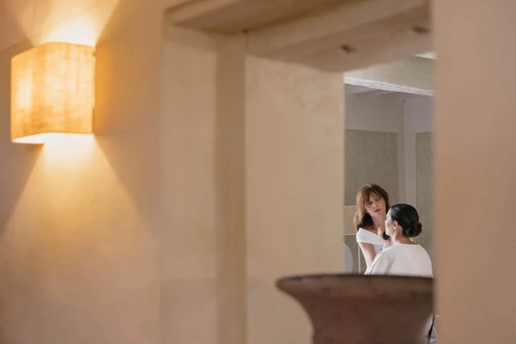 Bride and makeup artist preparing in the quiet interior of the convent