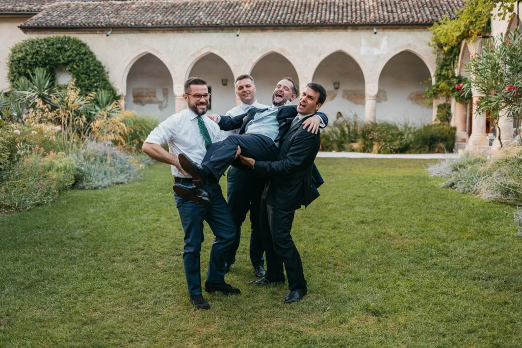 Group of groomsmen having fun on the lawn of Convento dell’Annunciata
