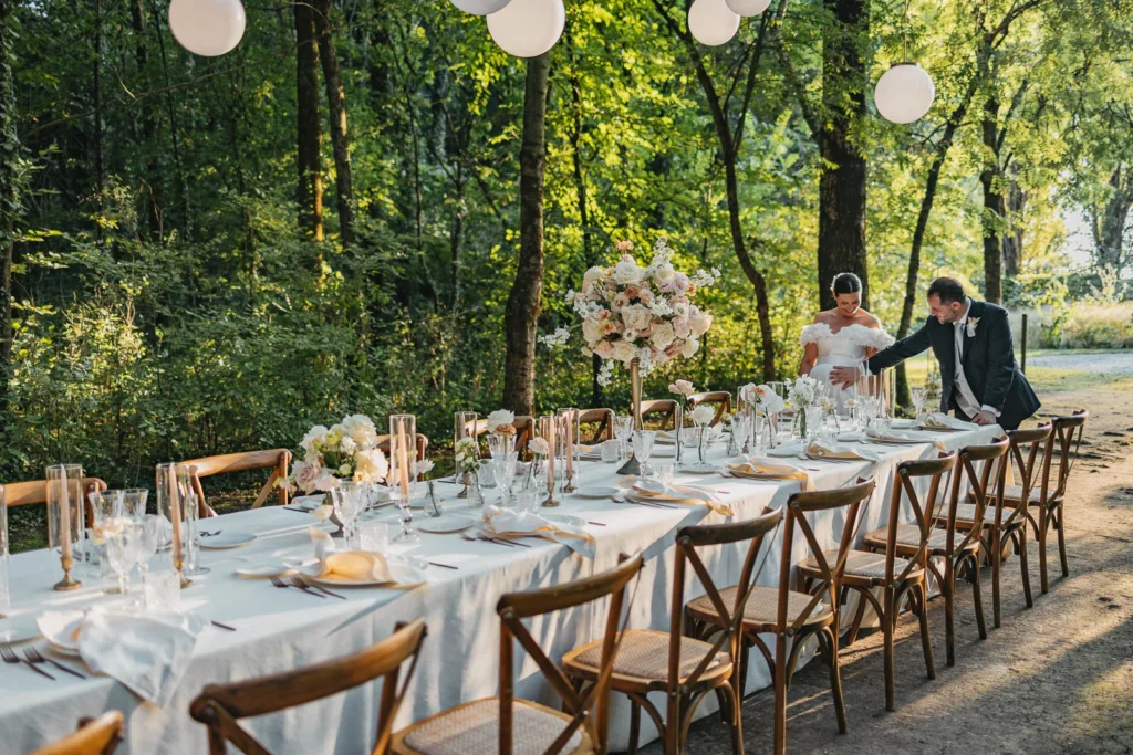 Elegant forest reception setup with floral centrepieces and wooden chairs