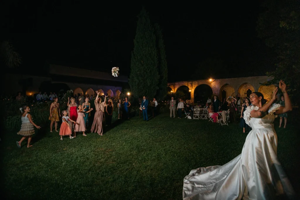 Guests preparing for the bouquet toss on the lawn under the stars