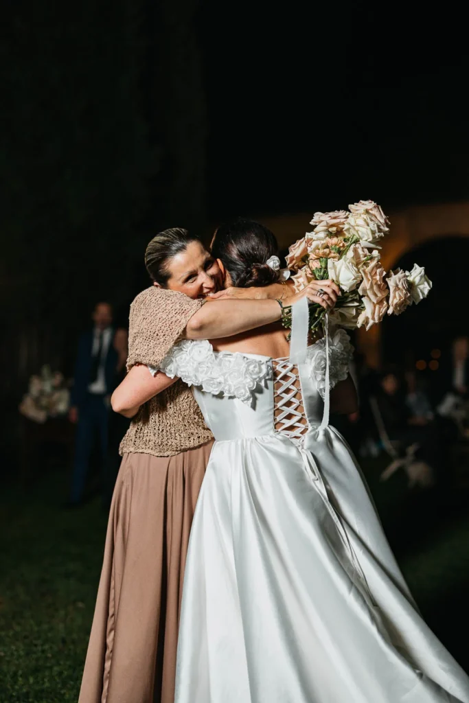 Bride hugging bouquet catcher after the toss moment