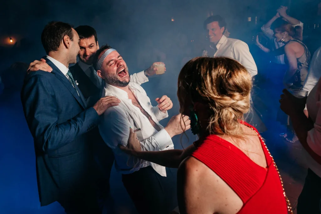 Groom and guests dancing wildly during wedding party