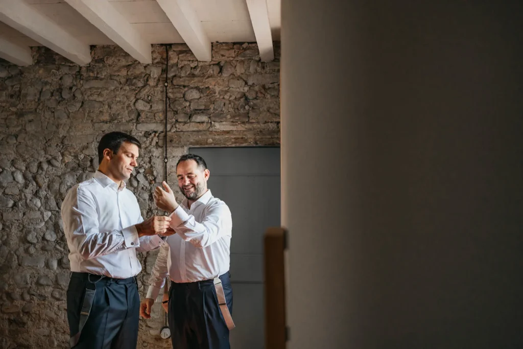 Groom getting ready and tying shoelaces on terracotta floor of the convent