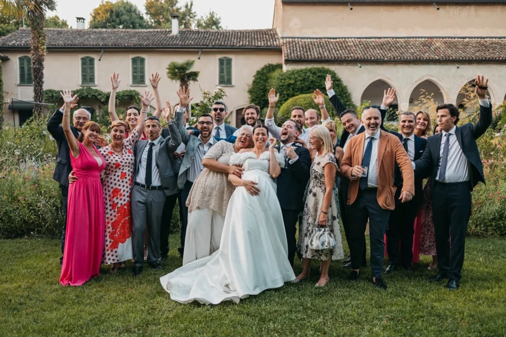 Bride and groom posing with extended family and guests after the ceremony
